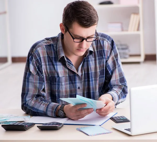 Junger Mann frustriert über sein Haus und Steuerrechnungen — Stockfoto