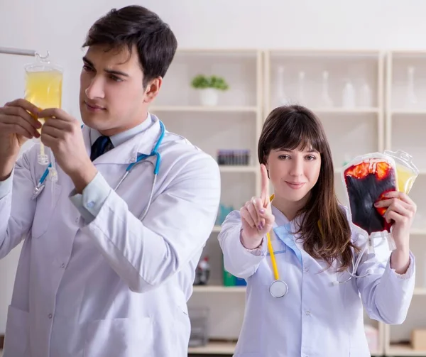 Dos doctores discutiendo plasma y transfusión de sangre — Foto de Stock