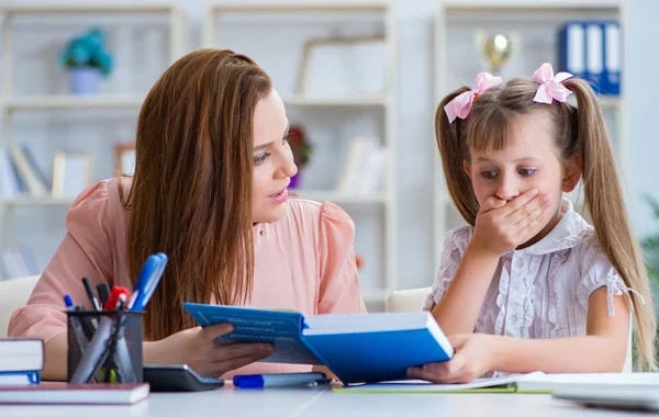 Mother helping her daughter to do homework — Stock Photo, Image