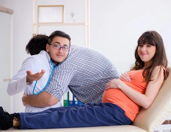Donna incinta con il marito in visita dal medico in clinica — Foto Stock