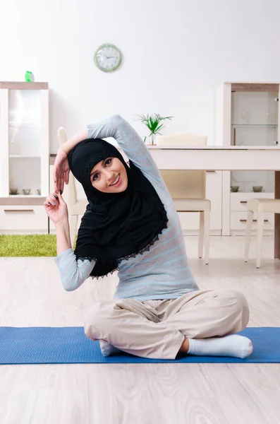 Junge Frau im Hidschab macht Übungen zu Hause — Stockfoto