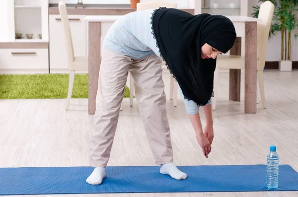 Jonge vrouw in hijab doet oefeningen thuis — Stockfoto