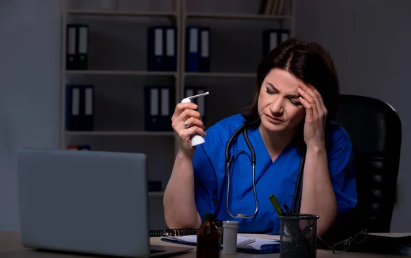 Médica idosa trabalhando no turno da noite — Fotografia de Stock