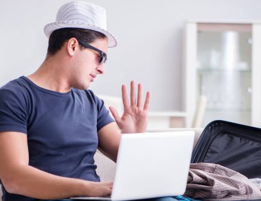 İnternet üzerinden seyahat ve otel rezervasyonu yapan bir adam.