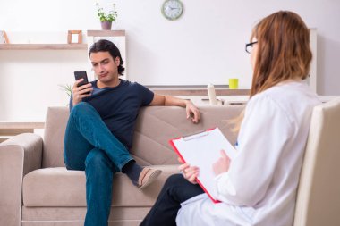 Genç bir erkek hasta kadın psikologla konuşuyor.