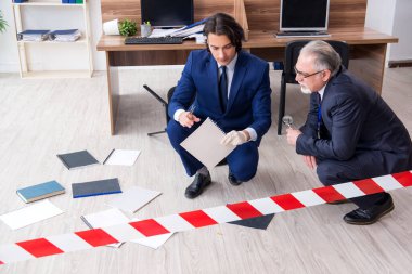 Ofiste çalışan iki kriminolog.