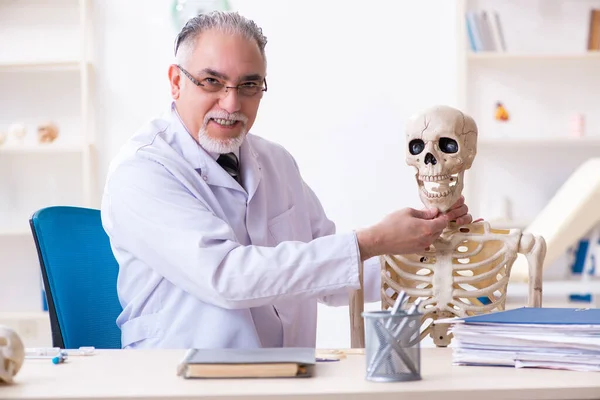 Homme âgé médecin avec squelette — Photo