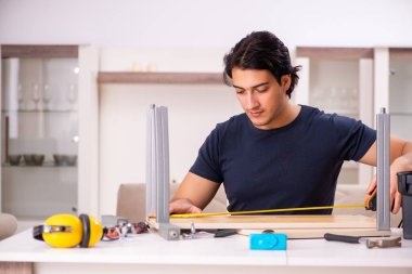 Evdeki mobilyaları tamir eden genç adam.