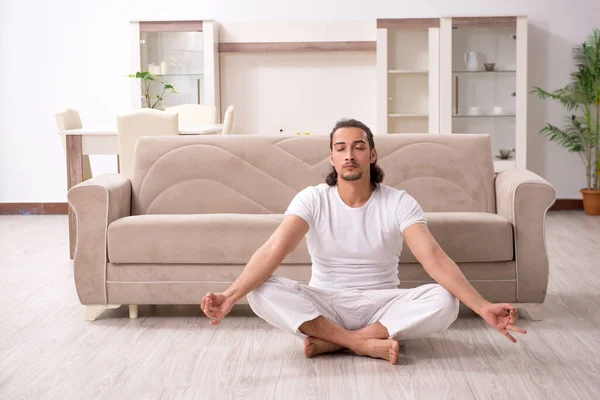 Joven haciendo ejercicios físicos en casa — Foto de Stock