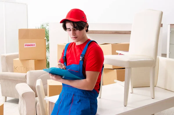 Jovem empreiteiro masculino com caixas trabalhando dentro de casa — Fotografia de Stock