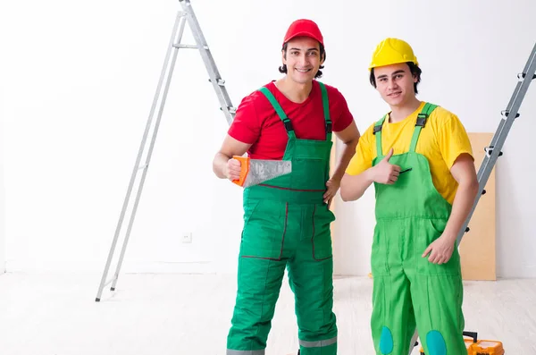 Dois trabalhadores empreiteiros que trabalham dentro de casa — Fotografia de Stock