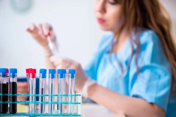 Asistente de laboratorio joven analizando muestras de sangre en el hospital — Foto de Stock