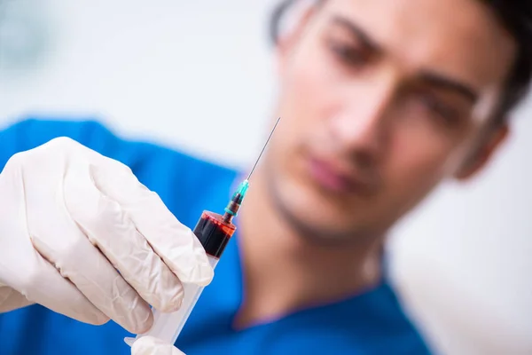 Jovem assistente de laboratório testando amostras de sangue no hospital — Fotografia de Stock