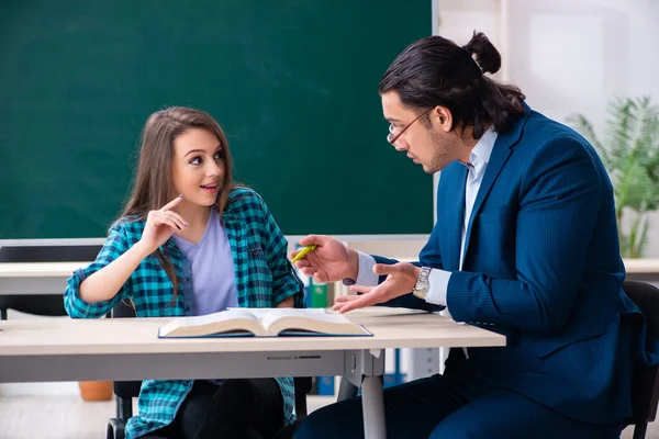 Jonge knappe leraar en vrouwelijke student in de klas — Stockfoto