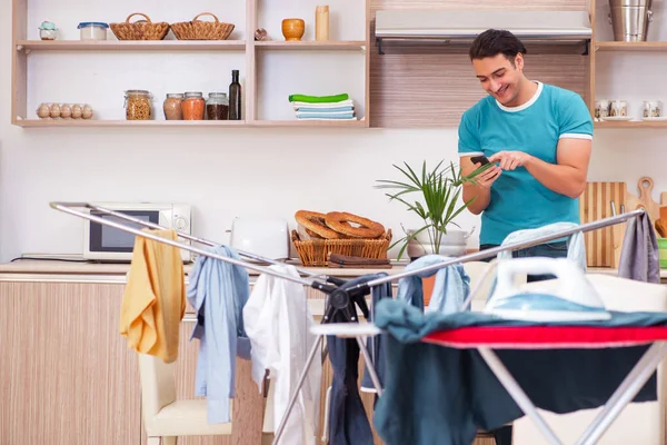 Junger Mann Ehemann bügelt Kleidung zu Hause — Stockfoto