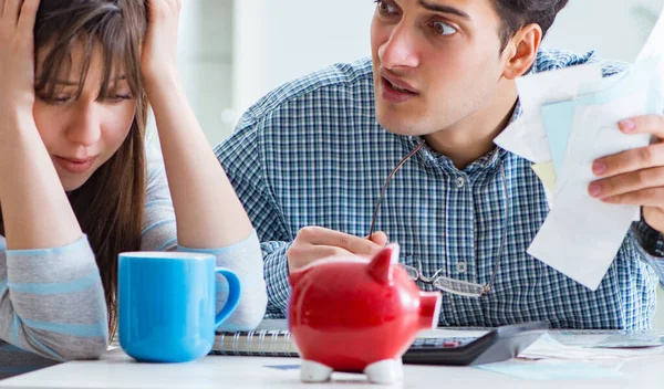 Junges Paar schaut auf Familienfinanzierungspapiere — Stockfoto