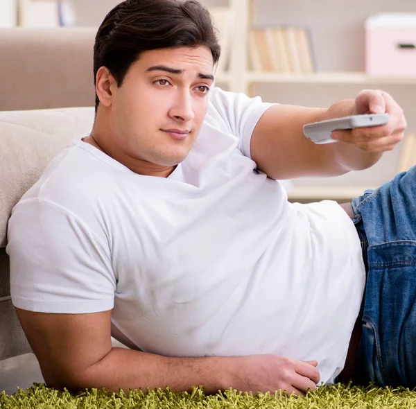 Чоловік дивиться телевізор вдома на підлозі — стокове фото