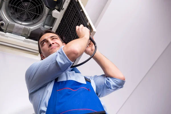 Jeune réparateur réparant unité de climatisation de plafond — Photo
