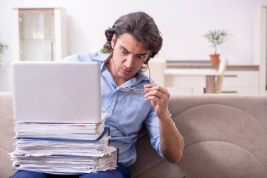 Evde çalışan genç bir erkek.