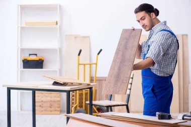 Genç erkek marangoz içeride çalışıyor.