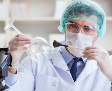 Adli tıp dedektifi suç delilleri üzerinde çalışıyor.