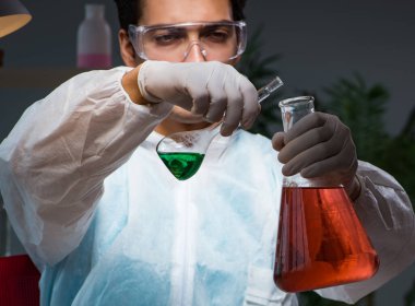 Gece geç saatlere kadar çalışan genç erkek kimyager.