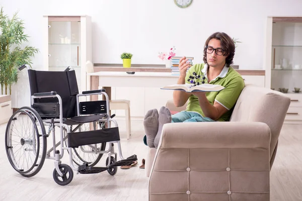 Mladý muž student na invalidním vozíku doma — Stock fotografie