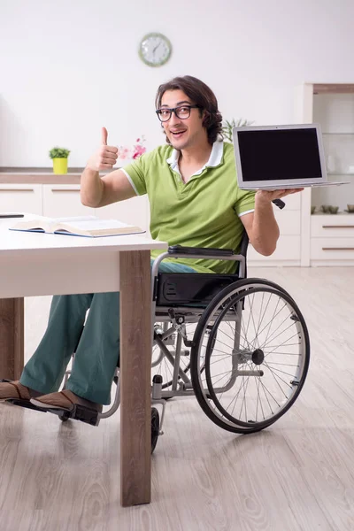Young male student in wheelchair at home — Stock Photo, Image