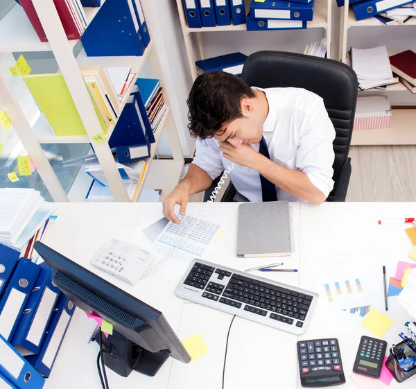 Empresario trabajando en la oficina con montones de libros y papeles — Foto de Stock