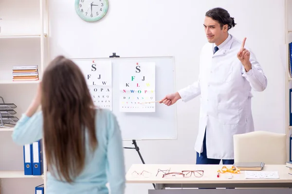 Mujer joven visitando médico oculista masculino —  Fotos de Stock