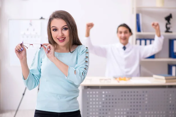 Jovem mulher visitando médico oculista masculino — Fotografia de Stock