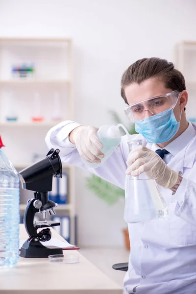 Joven químico masculino experimentando en laboratorio —  Fotos de Stock
