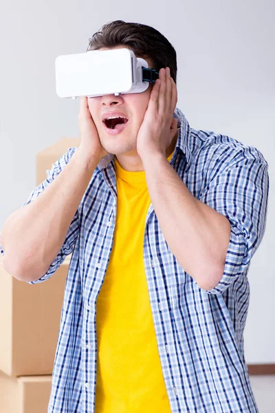 Young man wearing VR glasses moving in new apartment — Stock Photo, Image