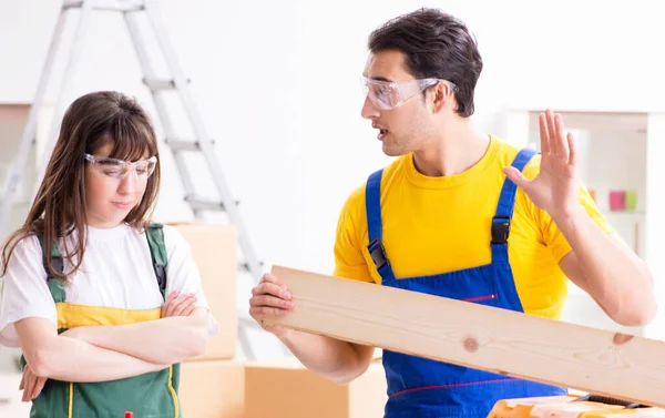 Uomo spiegando donna lavorazione del legno suggerimenti in laboratorio di legno — Foto Stock