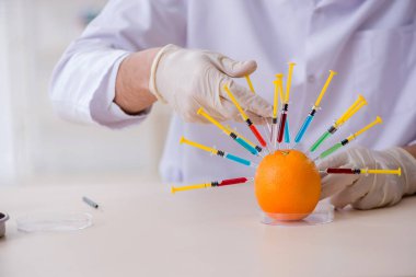 Erkek beslenme uzmanı gıda ürünlerini laboratuarda test ediyor.