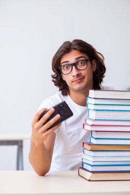 Sınıfta oturan genç erkek öğrenci.