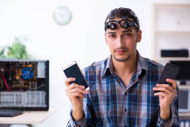 Genç yakışıklı teknisyen cep telefonu tamir