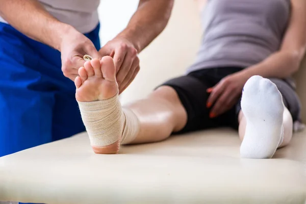 Leg injured woman visiting young doctor traumatologist — Stock Photo, Image