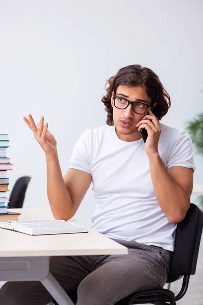 Joven estudiante masculino sentado en el aula — Foto de Stock