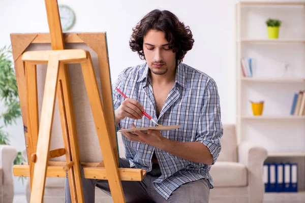 Jovem homem bonito curtindo pintura em casa — Fotografia de Stock