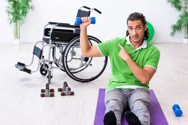 Joven en silla de ruedas haciendo ejercicios en interiores — Foto de Stock