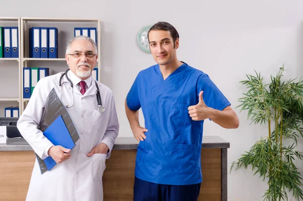 병원 안내 데스크에서 두 의사가 말하는 모습 — 스톡 사진