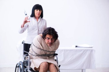 Yaşlı kadın psikiyatrist genç erkek hastayı ziyaret ediyor