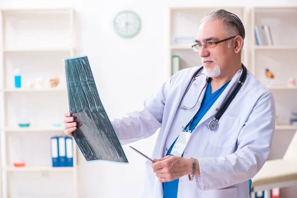 Gammal manlig läkare som arbetar på kliniken — Stockfoto