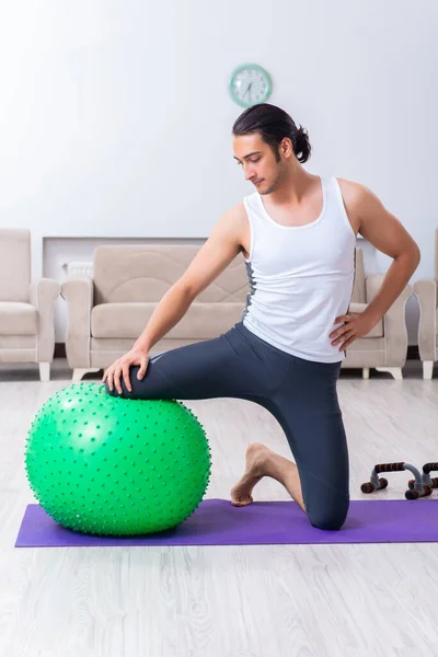 Joven entrenando y ejercitando en casa — Foto de Stock