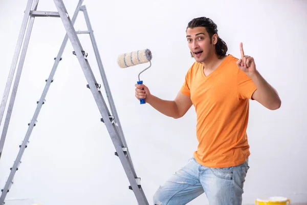 Молодой человек подрядчик делает ремонт на дому — стоковое фото