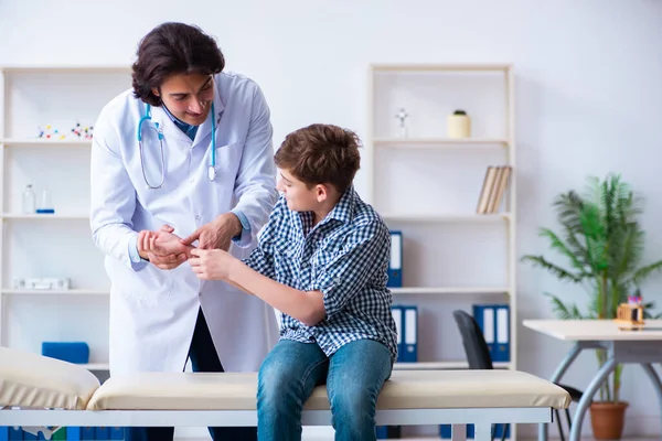 Раненый мальчик посещает молодого врача — стоковое фото
