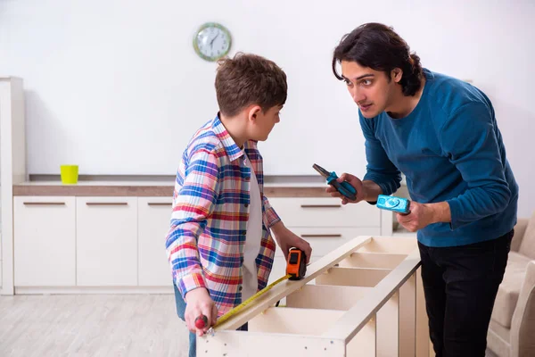 Jovem carpinteiro ensinando seu filho — Fotografia de Stock