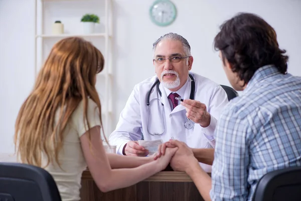 Giovane coppia visita vecchio medico maschio — Foto Stock