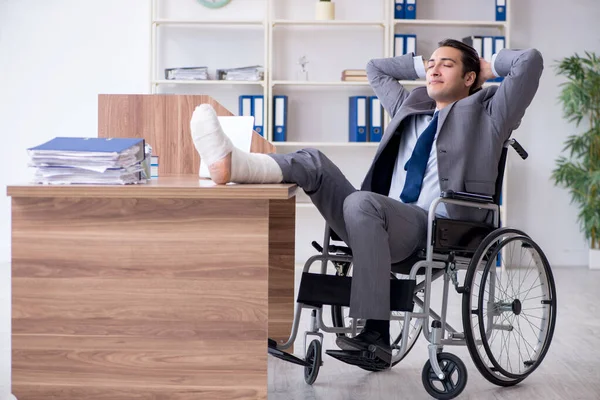 Чоловік у інвалідному кріслі в офісі — стокове фото